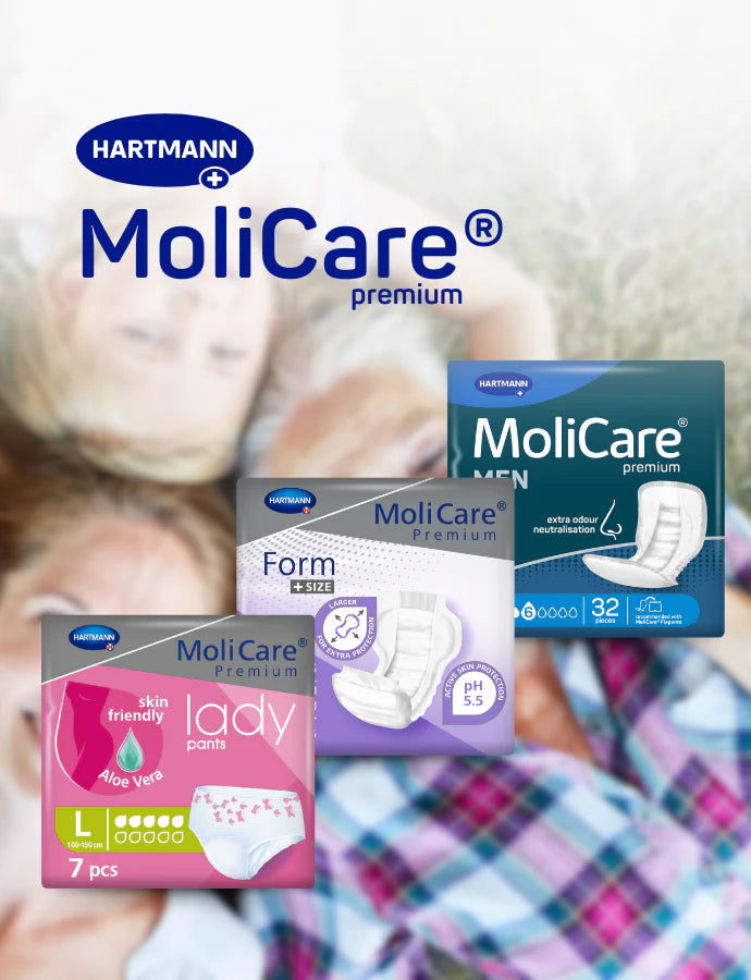 Im Vordergrund sind drei Verpackungen von Hartmann MoliCare Premium-Inkontinenzprodukten mit den Bezeichnungen Lady Pants, Form und Men abgebildet, im Hintergrund sind unscharf eine Person und ein Kind zu sehen, die auf einem Bett liegen.