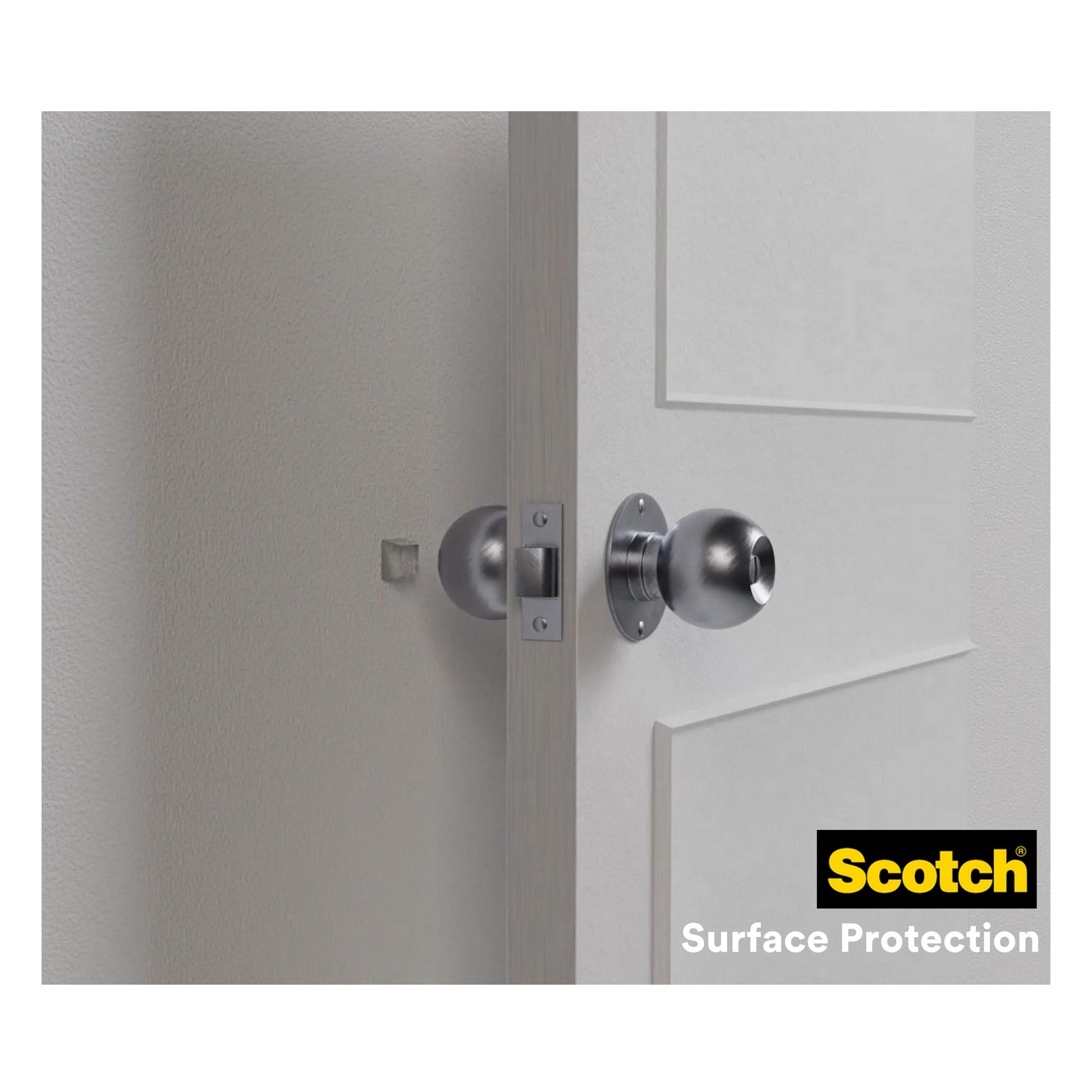 Ein metallischer Türknauf an einer weißen Tür berührt die Wand, die durch einen transparenten Scotch® Stoßabsorbierende Elastikpuffer für Wände SP91A64 (Ø 22 mm), selbstklebend von 3M Deutschland GmbH, geschützt ist. Die Verpackung zeigt das Logo von Scotch Surface Protection.