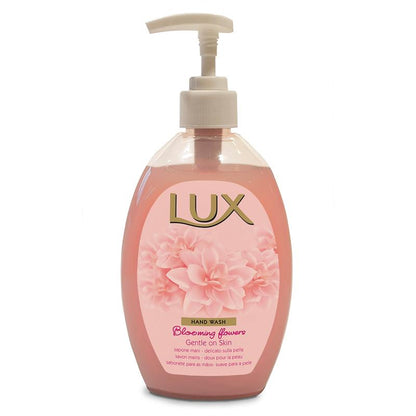 En genomskinlig plastflaska med LUX Pro Formula handtvål från Diversey Deutschland GmbH & Co. OHG, med rosa vätska, vit pump, blommig grafik och texten "Blooming Flowers Gentle on Skin" - hudvänlig med behaglig doft.