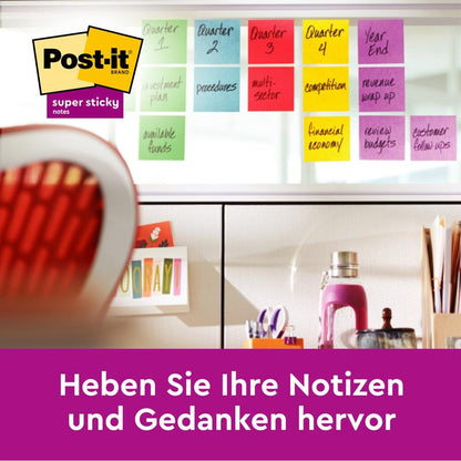 Ett skrivbord och en stol står framför ett fönster dekorerat med färgglada Post-it® Super Sticky Notes (76 mm x 127 mm, 90 blad/block, 100% PEFC) från 3M Deutschland GmbH. Den tyska texten under lyder: "Framhäv dina anteckningar och tankar.