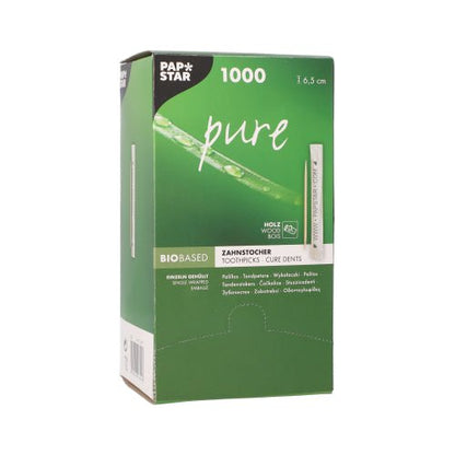 En grön dispenserlåda av PAPSTAR tandpetare "pure" rund, av trä, 6,5 cm från PAPSTAR GmbH innehåller 1000 trä-tandpetare och är på framsidan försedd med produktdetaljer och en tandpetarbild.