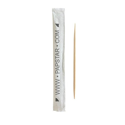 En PAPSTAR tandpetare "pure" rund, 6,5 cm av trä ligger bredvid det vita, miljövänliga pappersomslaget med svart tryck "www.papstar.com" från 1000-styck dispenserlådan från PAPSTAR GmbH.