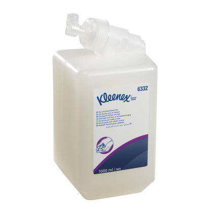 En klar 1L Kleenex® hår- och kroppsschampo kassett från Kimberly-Clark GmbH, med vit etikett och dispenser, innehåller information om mild vård och effektiv rengöring i blå och lila text. Säljs som 6 kassetter per kartong.