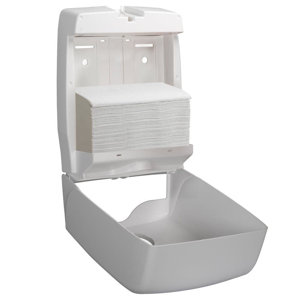 En vit, väggmonterad dispenser kan öppnas och ger fri sikt till Scott® CONTROL™ vikta handdukar - Vit (15 klipp x 212 ark | Kartong) från Kimberly-Clark GmbH, där den nedre täckningen är vinklad för att underlätta tillgången till hygieniska handdukar.
