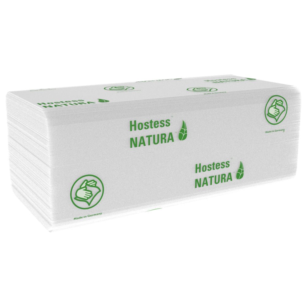 En hög av vita, vikta Hostess™ NATURA™ handdukar (Kimberly-Clark GmbH), stora, 20 x 84 ark, med grönt varumärke och tummen upp-symbol. Tillverkad i Tyskland - idealiska pappershanddukar för offentliga områden. 20 paket per kartong.