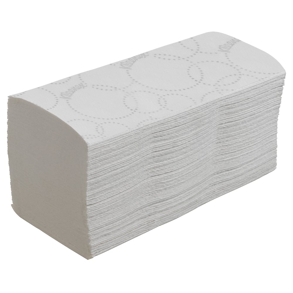 En stapel Kleenex® vikta pappershanddukar Interfold, vit med diskret prägling, från Kimberly-Clark GmbH - 15 clips x 186 ark per kartong - lätt vinklad på en enkel vit bakgrund.