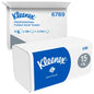 En kartong Kleenex® vikta pappershanddukar från Kimberly-Clark GmbH (vit, mellanvikning) innehåller 15 förpackningar med vardera 186 ark - totalt 2 790 engångshanddukar. Blå och vit branding; öppen fraktkartong synlig i bakgrunden.