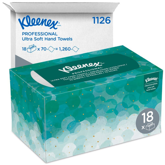 En förpackning med Kleenex® Ultra™-handdukar Interfold (vita, medelstora, 70 stycken) från Kimberly-Clark GmbH avbildas framför en vit fraktkartong med texten ”1126” och ”18 x 70 = 1 260”, i vilken det finns 18 hygienförpackningar.