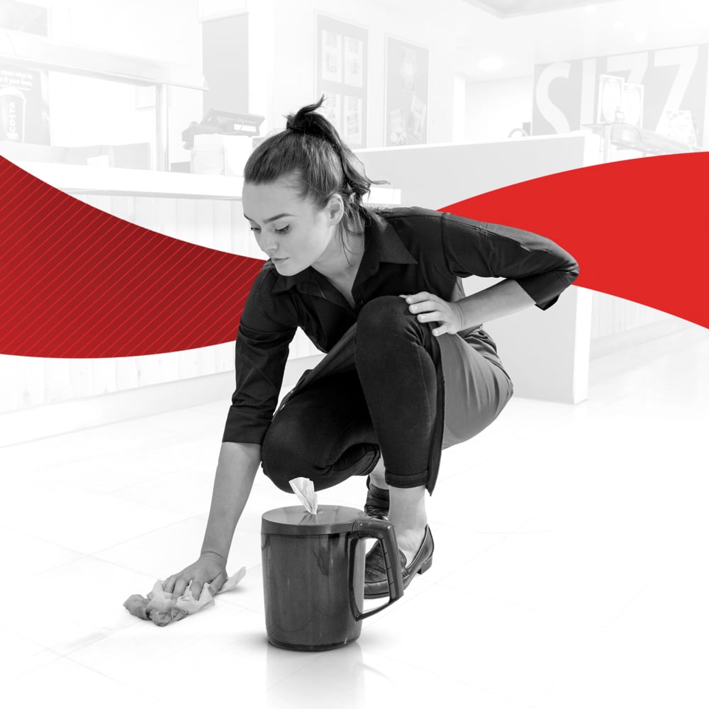 En kvinna i mörka kläder rengör golvet med en WypAll® Reach™ pappershandduk från Kimberly-Clark GmbH. Framför henne står en hink med tillbehör. Scenen mot en vit och röd bakgrund visar rengöring av service- och försäljningsutrymmen.