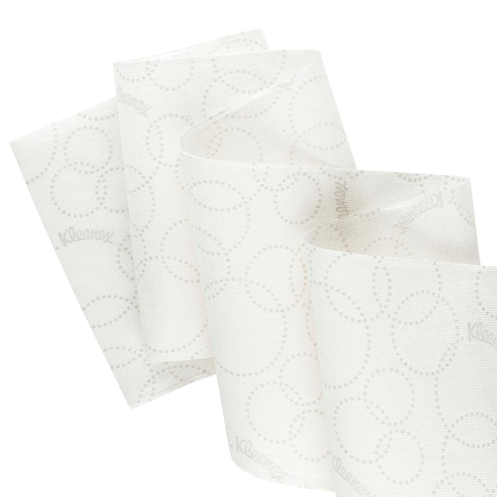 Närbild av en vit Kleenex® Ultra™ Slimroll™ pappershandduksrulle från Kimberly-Clark GmbH med subtilt prickmönster och delvis utrullning för att visa dess lämplighet för smala dispensersystem; 6 rullar per kartong.