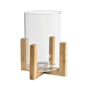 Den dekorativa bordslampan ESME från Duni GmbH består av en cylinder av klart glas (15x15 cm) på ett träställ med fyra ben och korsformad bas. Den kombinerar modern stil med funktionell design, liknande den minimalistiska Esme Box.