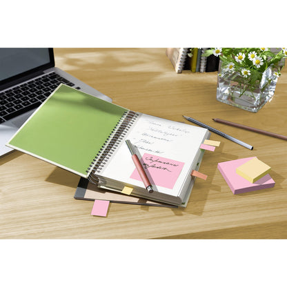 Ein Spiralnotizbuch mit handschriftlichen Notizen, ein rosa Kugelschreiber, ein Bleistift und ein Laptop liegen auf einem Holztisch neben den Post-it® Recycling Z-Notes (76x76 mm, 100% PEFC) der 3M Deutschland GmbH. Eine Glasvase mit weißen Gänseblümchen und Grünzeug steht im Hintergrund.