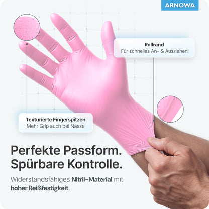 Avbildad är en hand i ARNOMED NITRIL BLOSSOM ROSE engångshandskar av rosa nitril från ARNOWA GmbH. Texturerade fingertoppar ger grepp, en rullkant möjliggör lätt påtagning och handsken erbjuder perfekt passform, hög rivstyrka och är latexfri.