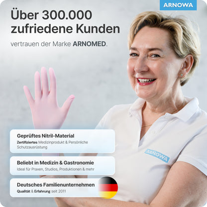 En leende kvinna i en vit piké och ARNOMED NITRIL BLOSSOM ROSE engångshandskar av rosa nitril höjer sin behandskade hand. Texten hänvisar till 300.000+ nöjda kunder, de latexfri egenskaperna och företagsinformationen om ARNOWA GmbH.