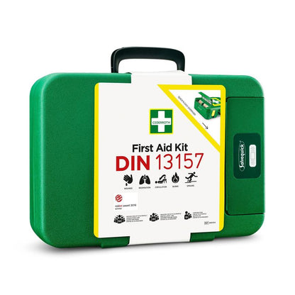 Den gröna Första hjälpen-lådan DIN | Förpackning (1 styck) i plast från Orkla Wound Care AB har en vit etikett med texten "First Aid Kit DIN 13157", ikoniska symboler och är en oumbärlig nödsats.