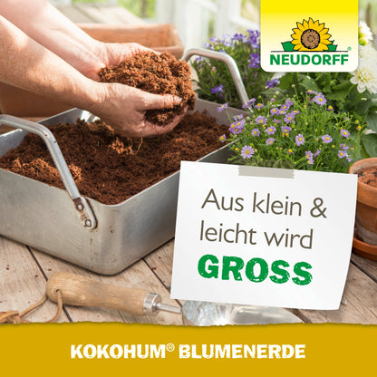 Eine Person füllt von Hand einen Metallbehälter mit Kokohum BlumenErde von Neudorff Shop. In der Nähe blüht eine Topfpflanze mit lila und weißen Blüten, begleitet von einem deutschen Text, der für diese Blumenerde wirbt.