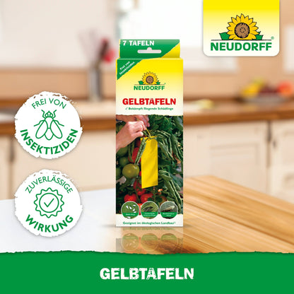 På ett köksbord står en låda Neudorff Shop Gulplattor (liten storlek) med gula klisterfällor för växter och texten "fri från insekticider" med pålitlig effekt mot skadedjur som vita flygare.