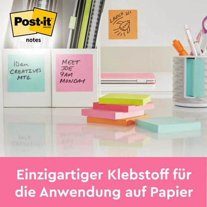 På ett städat skrivbord finns Post-it® Notes (63,5 mm x 76 mm, 100 blad/block, 100% PEFC) från 3M Deutschland GmbH i olika färger och en tysk hänvisning till det pappervänliga limmet på dessa klisterlappar.