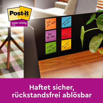 En datorskärm med sex färgglada Post-it® Super Sticky Notes i stort format (101 x 101 mm, 90 blad/block, 100% PEFC) från 3M Deutschland GmbH. I bakgrunden syns en växt och en stol.