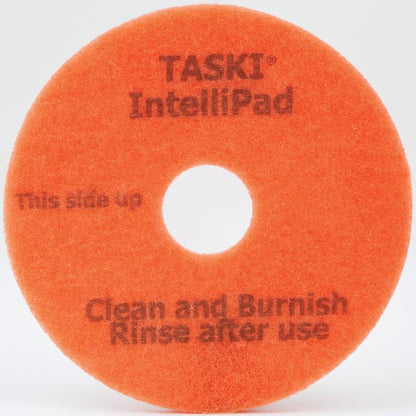 En rund, orange "TASKI Intellipad Kombinerad rengörings- och polerpad för underhållsrengöring" från Diversey Deutschland GmbH & Co. OHG, med "This side up"-text, mittshål, strukturerad yta - idealisk för rengöring och polering.