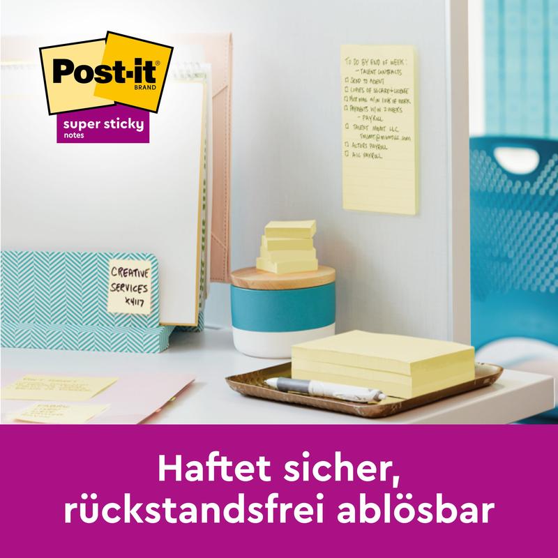En arbetsplats med Post-it® Super Sticky 100 % återvinningslappar (76x76 mm, 70 blad, 100% PEFC) från 3M Deutschland GmbH på en vägg och en bricka. En lapp är vertikalt placerad. Text: "Sitter säkert, lätt att ta bort utan spår."
