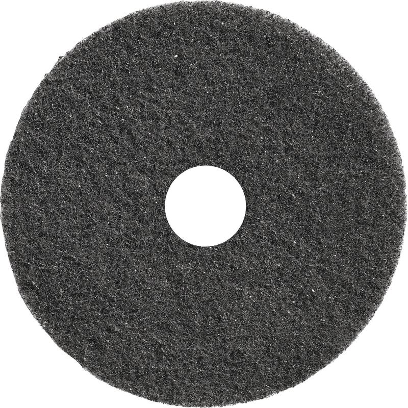 En rund, svart TASKI Americo Dominator Pad 17" (43 cm) från Diversey Deutschland GmbH & Co. OHG med grov textur och mitteshål - en extra aggressiv grundrengöringspad, idealisk för intensiv golvrengöring (förpackning: 1 styck).