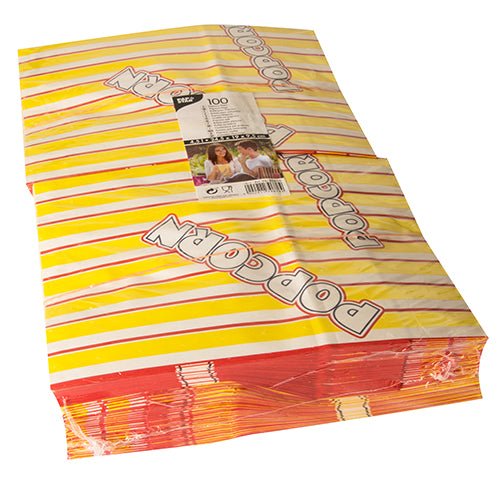 Avbildad är en stapel PAPSTAR 100 popcornpåsar, gul-röd randiga fettresistenta pergamentersättningspåsar med den sneda trycket "POPCORN", med en synlig förpackningsetikett från PAPSTAR GmbH ovanpå.