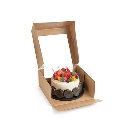 En liten rund tårta med olika frukter presenteras i en öppen PAPSTAR 25 tårtkartonger med lock fyrkantig med fönster av PLA från PAPSTAR GmbH mot vit bakgrund.