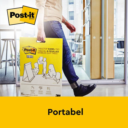 En person bär ett 3M Deutschland GmbH Post-it® Super Sticky självhäftande mötesblock/flipchart med stativ (58,4 x 50,8 cm, 20 blad, PEFC-certifierad) i huset, där Post-it-logotypen och "Portabel" är synliga.