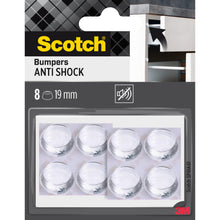 Eine Einzelhandelspackung Scotch® Stoßabsorbierende Elastikpuffer, selbsthaftend, transparent (8 klare runde Puffer, 19 mm) der 3M Deutschland GmbH, abgebildet mit Produktbranding und einem Puffer auf einer Schranktür.