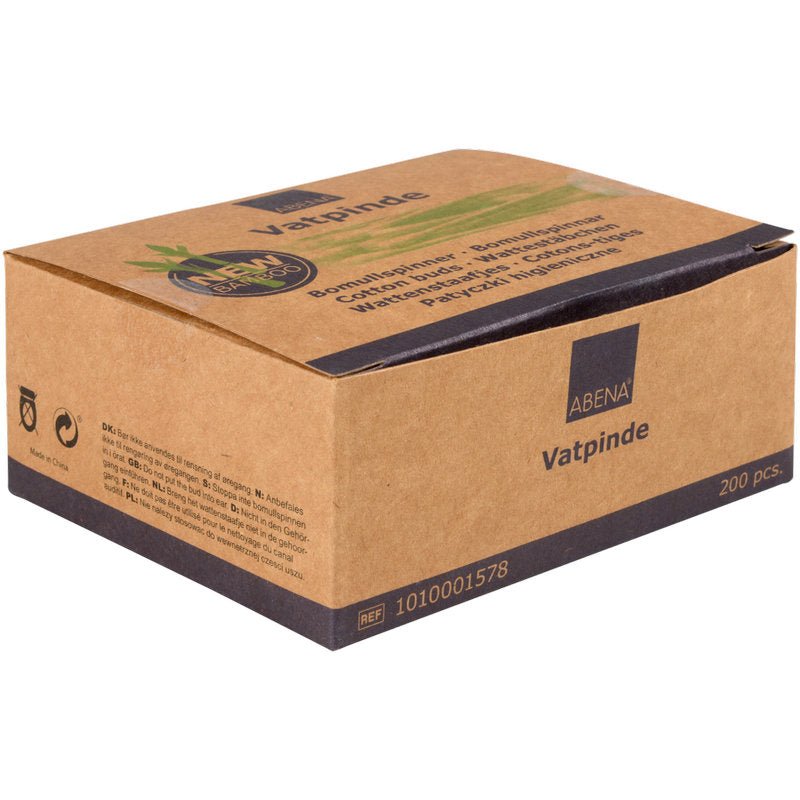 En brun kartong med texten "Abena Re-Seller GmbH" innehåller 200 hållbara bomullspinnar (7,5 cm) av bambu och bomull. Förpackningen är dekorerad med gröna växter och är idealisk för miljömedvetna användare.