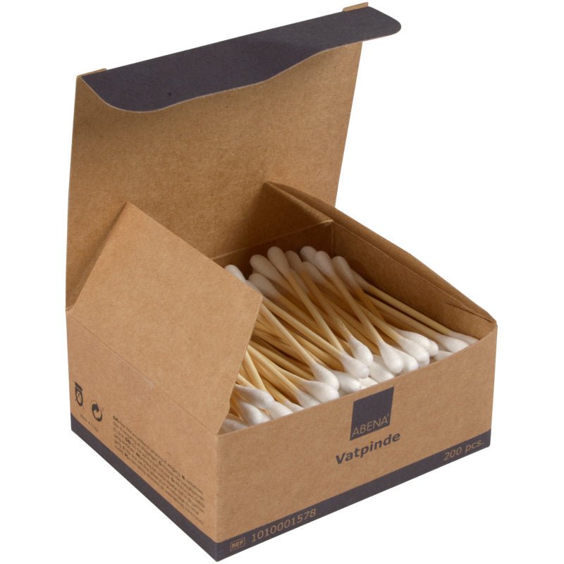 En öppen brun låda med texten "Abena vatpinde" innehåller 200 bambu/bomullspinnar (7,5 cm) från Abena Re-Seller GmbH. Lådan är delvis fylld och erbjuder enkel åtkomst till de miljövänliga bomullspinnarna.
