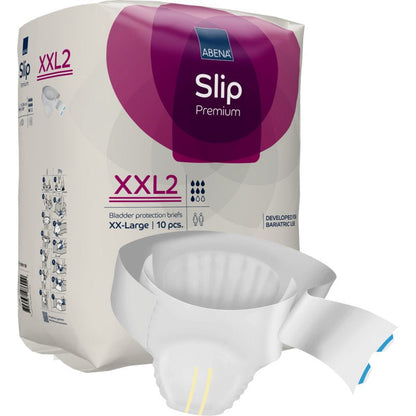 Ett paket ABENA Slip Premium från Abena Re-Seller GmbH är utställt, en delvis uppackad slip ligger framför. Den lila-vita förpackningen betonar storleken XX-Large, 10 stycken, och den pålitliga inkontinensvården.