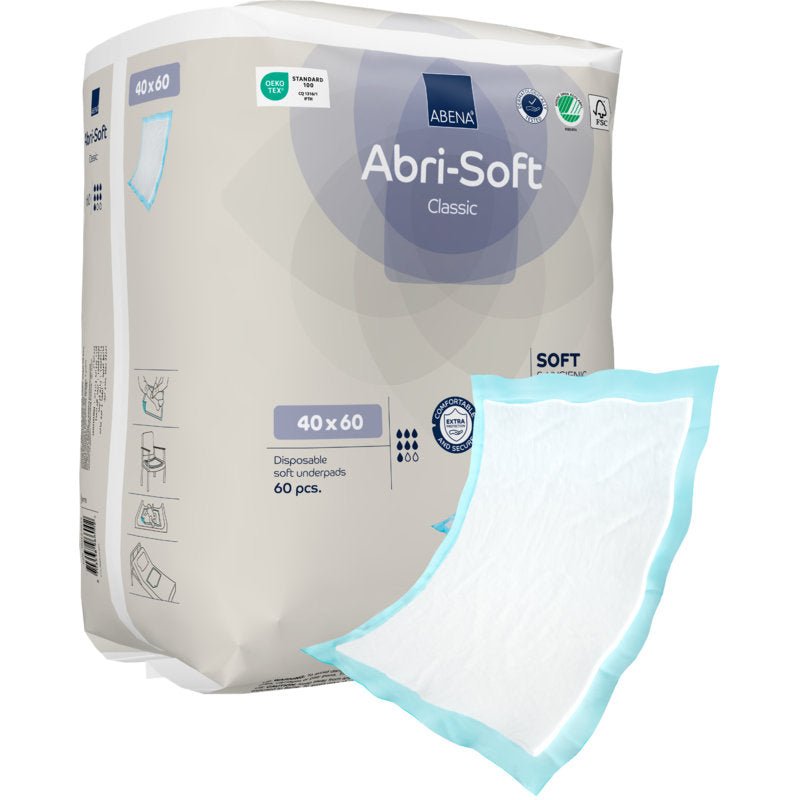 Avbildad är ett 60-pack av Abena Re-Seller GmbH engångsunderlägg Abri-Soft Classic (40x60 cm, blå) med ett underlägg utanför förpackningen med vit sugkärna och blå kant.
