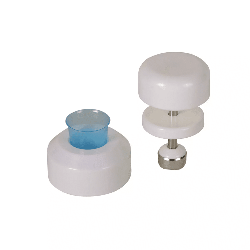 Mot en vit bakgrund syns två vita köksverktyg av plast. Verktyget till vänster har en cylindrisk form med en blå plastinsats, medan verktyget till höger är en AMPri tablettkross för medicinkoppar från AMPri Handelsgesellschaft mbH, som består av två vita skivor som är förbundna med en rostfri stång med en metallbas.