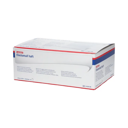 En låda BSN Elastomull® haft, ett vitt elastiskt gasband från BSN Medical GmbH, ställs ut. Förpackningen har blå och röda accenter som framhäver etiketten som ett elastiskt fixeringsband. Texten på lådan innehåller produktinformation och specifikationer på flera språk.