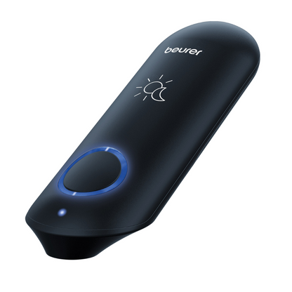 En svart, bärbar elektronisk insektsbettbehandlare BR 90 från Beurer med rundad ovansida och en blåbelyst rund knapp på framsidan. Varumärket „Beurer GmbH“ är tryckt ovanpå och ovanför knappen för insektsbettbehandling finns en symbol med en sol och en halvmåne.