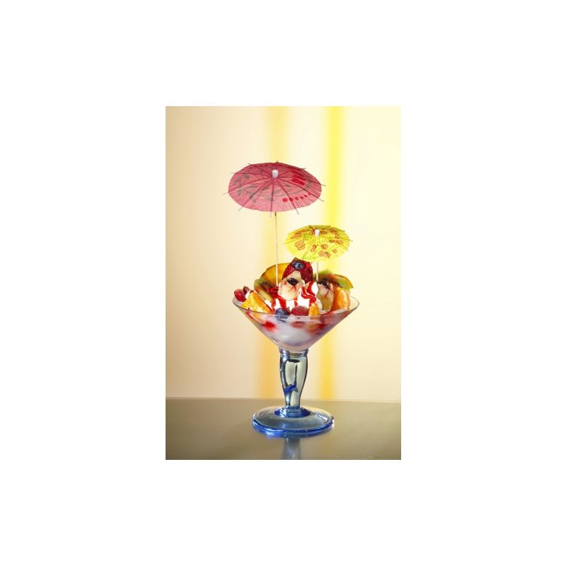 I ett glas står en färgglad glasskopp, dekorerad med körsbärsbollar, skuren frukt och färgglada PAPSTAR Dekorationsplockare från PAPSTAR GmbH. Den mjukt upplysta bakgrunden framhäver desserten på bästa sätt.