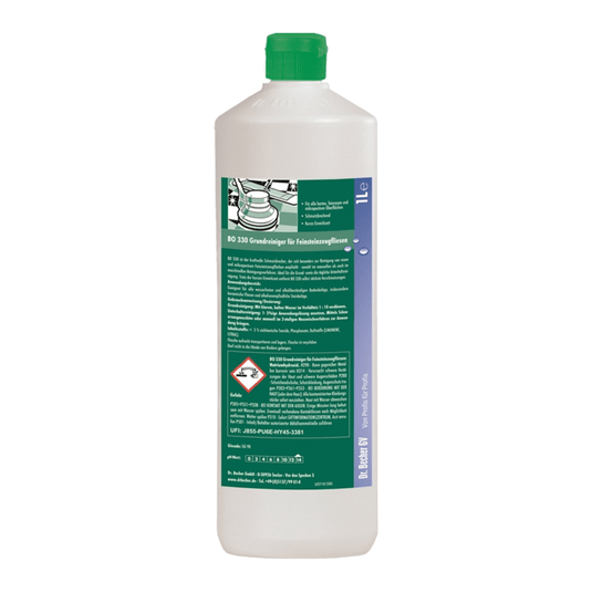 En vit plastflaska med grönt lock. På etiketten syns en grön-vit text med säkerhets- och produktinformation, en grön bild av en bil samt olika farosymboler. Perfekt för rengöring är Dr. Becher BO 330 Grundrengöringsmedel för finstenplattor från Dr. Becher GmbH.