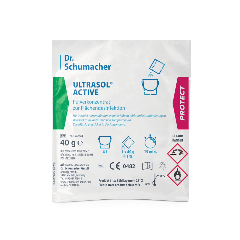 En förpackning Dr. Schumacher Ultrasol® Active ytdesinfektion från Dr. Schumacher GmbH innehåller pulverkoncentrat för ytdesinfektion. Den vita förpackningen med gröna och rosa accenter innehåller text och symboler som indikerar att den innehåller 40 gram pulverkoncentrat för ytdesinfektion och bör förvaras under 25 °C. På förpackningen finns även farosymboler.