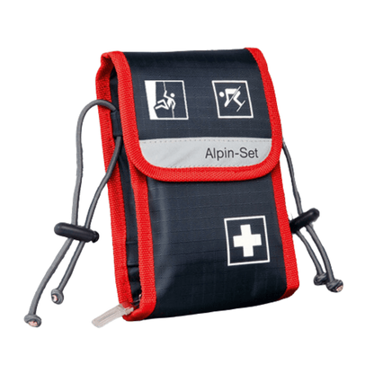 Ett kompakt första hjälpen-set i marinblått och rött med vita symboler som föreställer olika nödsituationer. Holthaus Medical GmbH & Co. KG:s Alpin-Set förbandsväska – 21 delar – har texten ”Erste-Hilfe-Set” och är försedd med justerbara dragband på båda sidor.