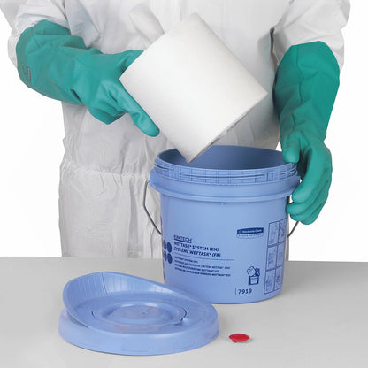 En person i en vit-grön skyddsdräkt lägger en vit rulle Kimberly-Clark GmbH WypAll® Wettask™ torkdukar (6 påfyllningar x 90 ark, vit) i en blå hink.