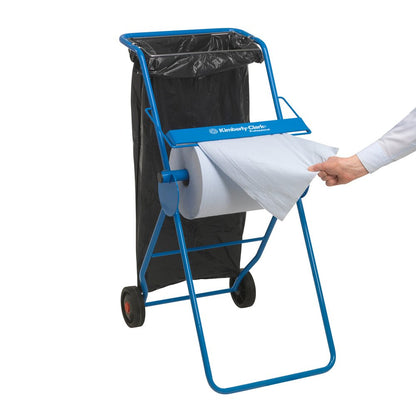 En blå pappershanddukshållare med en svart soppåse syns medan en hand drar ut ett ark från en WypAll® X60 General Clean stor rulle (1 rulle x 500 ark, blå) från Kimberly-Clark GmbH - idealisk för professionella rengöringsuppgifter.