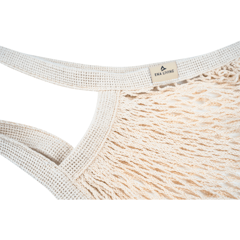 Närbild av det beige ENA Living shoppingnätet från Abena Re-Seller GmbH med tjocka, flätade handtag och en liten "ENA LIVING"-skylt. Idealisk för miljömedvetna inköp. Förpackningsenhet: kartong (24 förpackningar), bakgrund: vit.