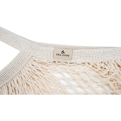 Närbild av ett cremefärgat ENA Living shoppingnät från Abena Re-Seller GmbH med stabilt, flätat handtag och "ENA LIVING"-etikett - perfekt för miljömedveten shopping; finns som kartong (24 förpackningar).