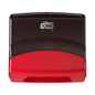 En Tork 654008 singelhanddukdispenser Performance W4 pappershanddukdispenser är monterad på en vit vägg. Den övre delen är svart och den nedre röd. Tork-logotypen, som är kopplad till Essity Professional Hygiene Germany GmbH, visas i vitt på det svarta området.