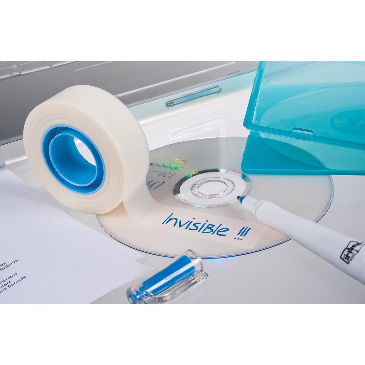Eine Rolle 3M Deutschland GmbH Scotch® unsichtbares Klebeband, ablösbar, 19 mm x 33 m, liegt mit einer beschrifteten CD "Invisible !!!", einem blauen Marker, einem USB-Stick, Papier und einer geöffneten blauen CD-Hülle auf einer weißen Fläche neben einem Laptop.