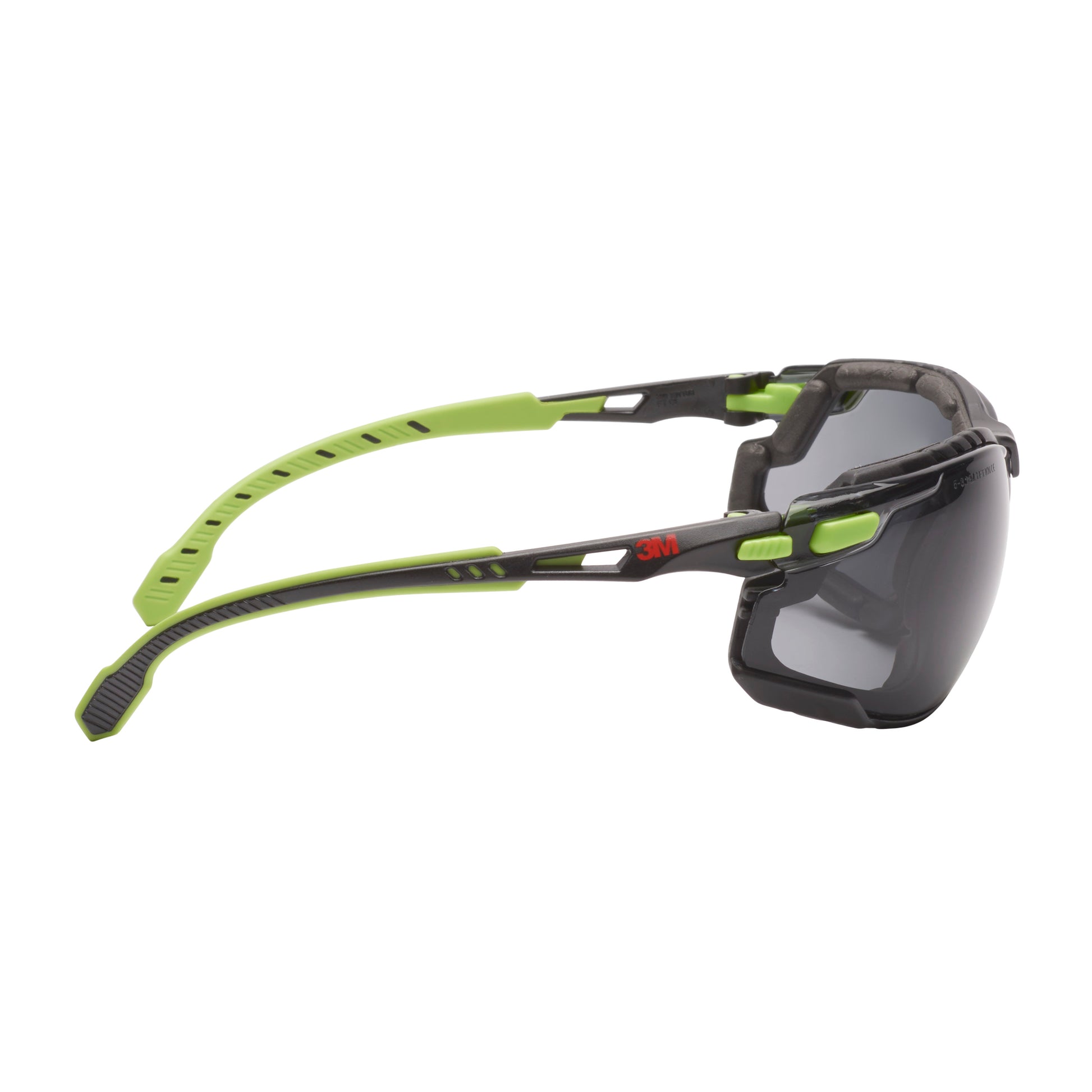 Seitenansicht der 3M™ Solus™ Schutzbrille 1000 von 3M Deutschland GmbH, grün/schwarz mit grauen Gläsern, verstellbaren Bügeln und aufsteckbarer Schaumstoffdichtung, mit Scotchgard™ Anti-Beschlag-Beschichtung vor weißem Hintergrund.