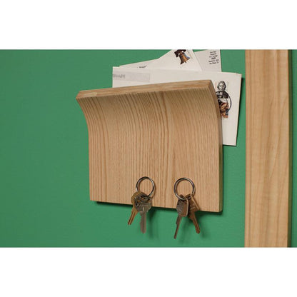 En träväggbrevlåda med krokar för nycklar är fäst med Scotch-FIX™ Dubbelsidigt inomhusmonteringstejp från 3M Deutschland GmbH på en grön vägg.