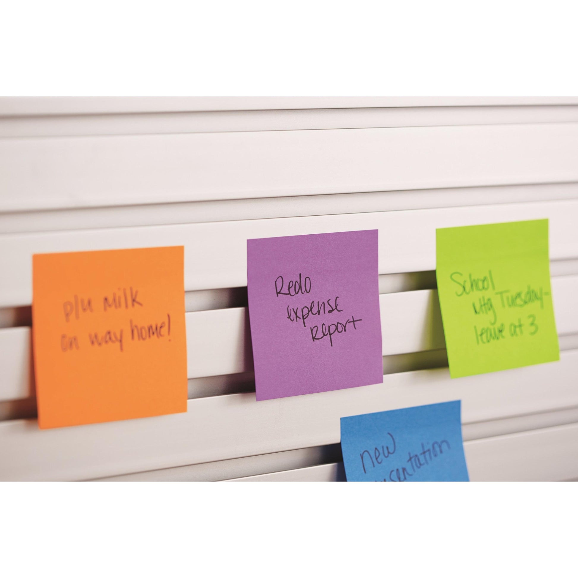 Drei 3M Post-it® Notes in verschiedenen Neonfarben (38mm x 51mm, 100 Blatt/Block, 3 Blöcke/Packung) sind an einer weißen Lamellenfläche angebracht und zeigen Erinnerungen und Notizen.